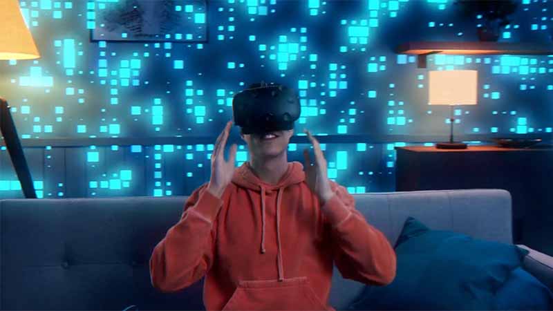 Hombre joven utilizando lentes de realidad virtual en una habitación con detalles luminosos